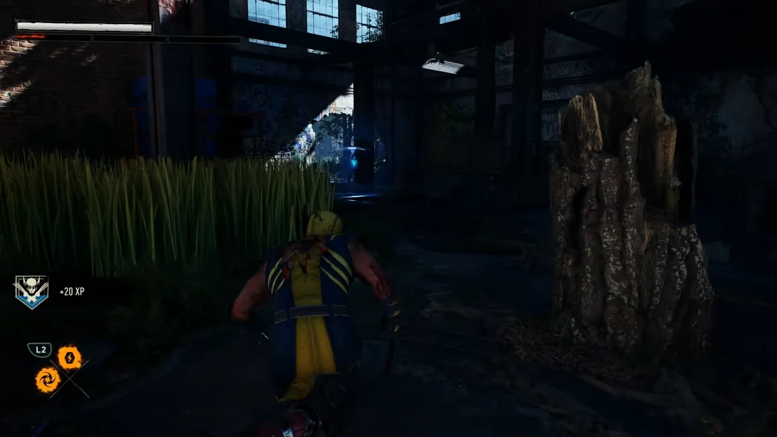 Wolverine crouch-walking through a dark overgrown industrial area with the L2 prompt and plus 20 XP visible