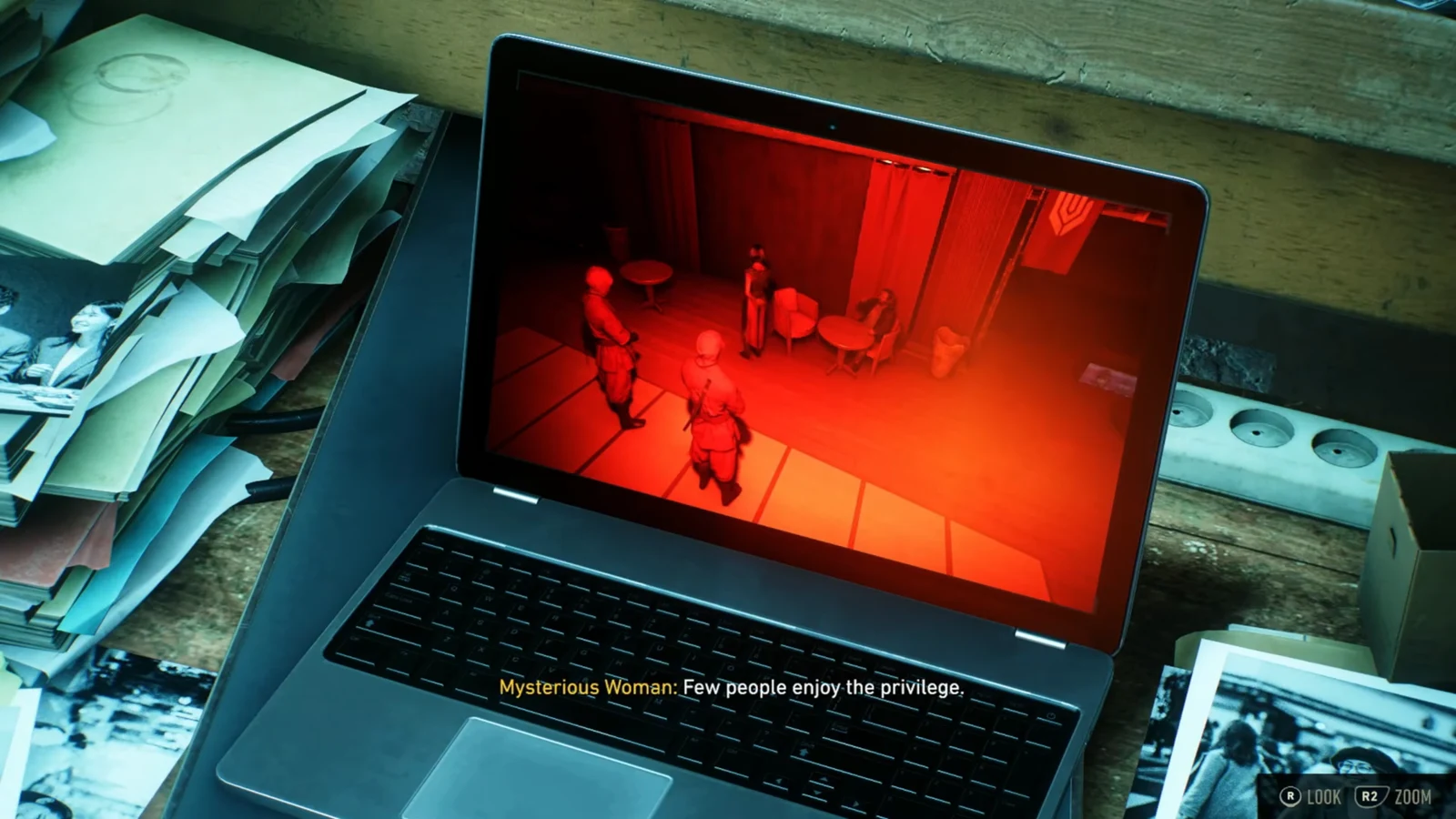 Logan zooming in on a laptop screen showing red-lit security camera footage