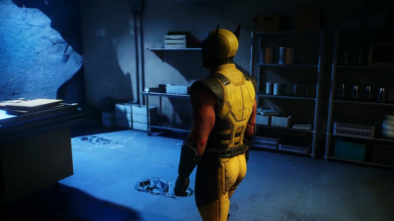 Wolverine in his yellow suit walks past shelving in a dim storage room with a broken floor