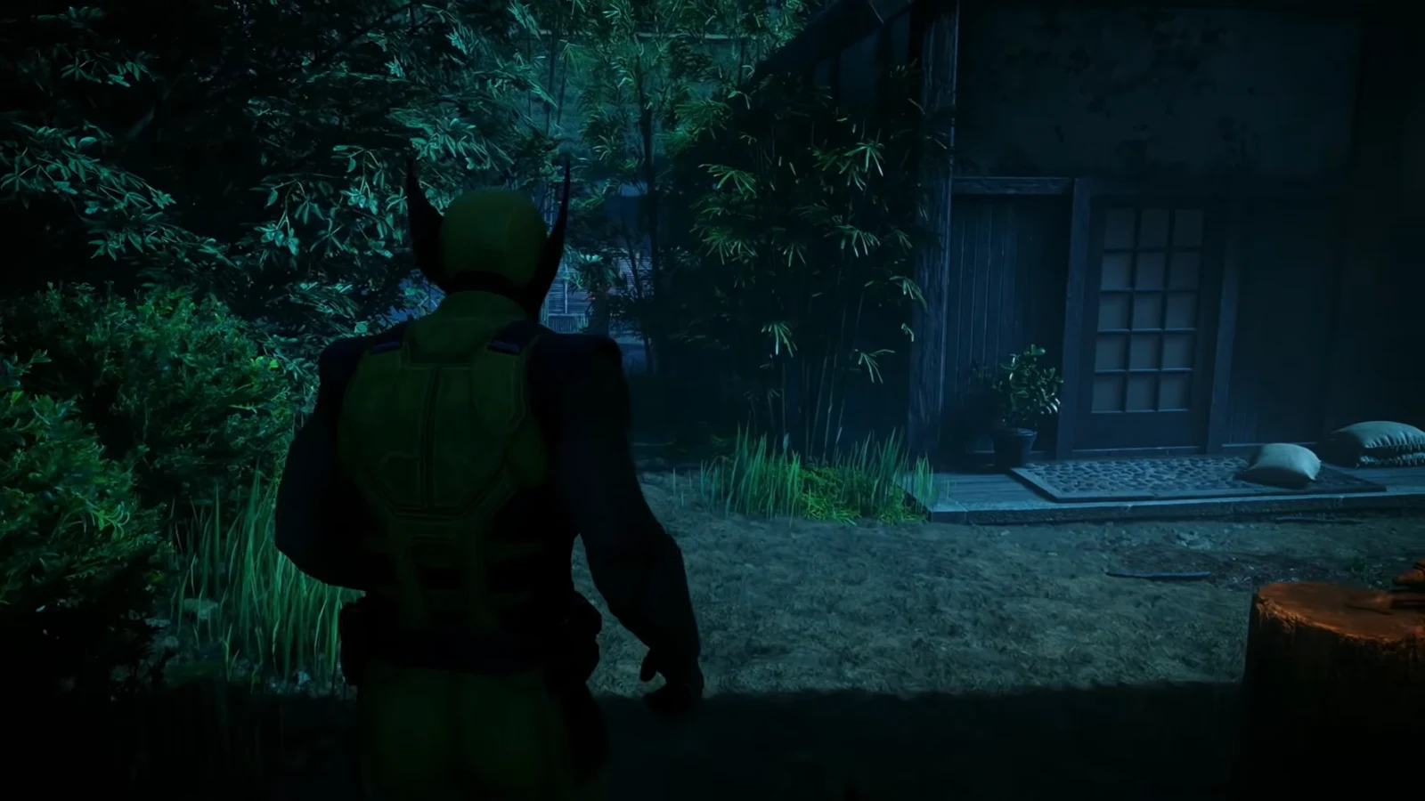 Logan walking through the deserted Mount Haku village toward a wooden house in the dark