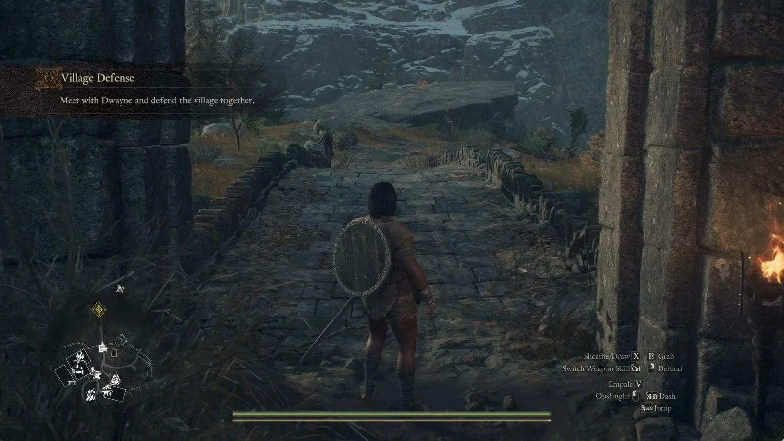 Character with a round shield on their back walks along a stone bridge between rocky, snowy hills toward a distant figure.