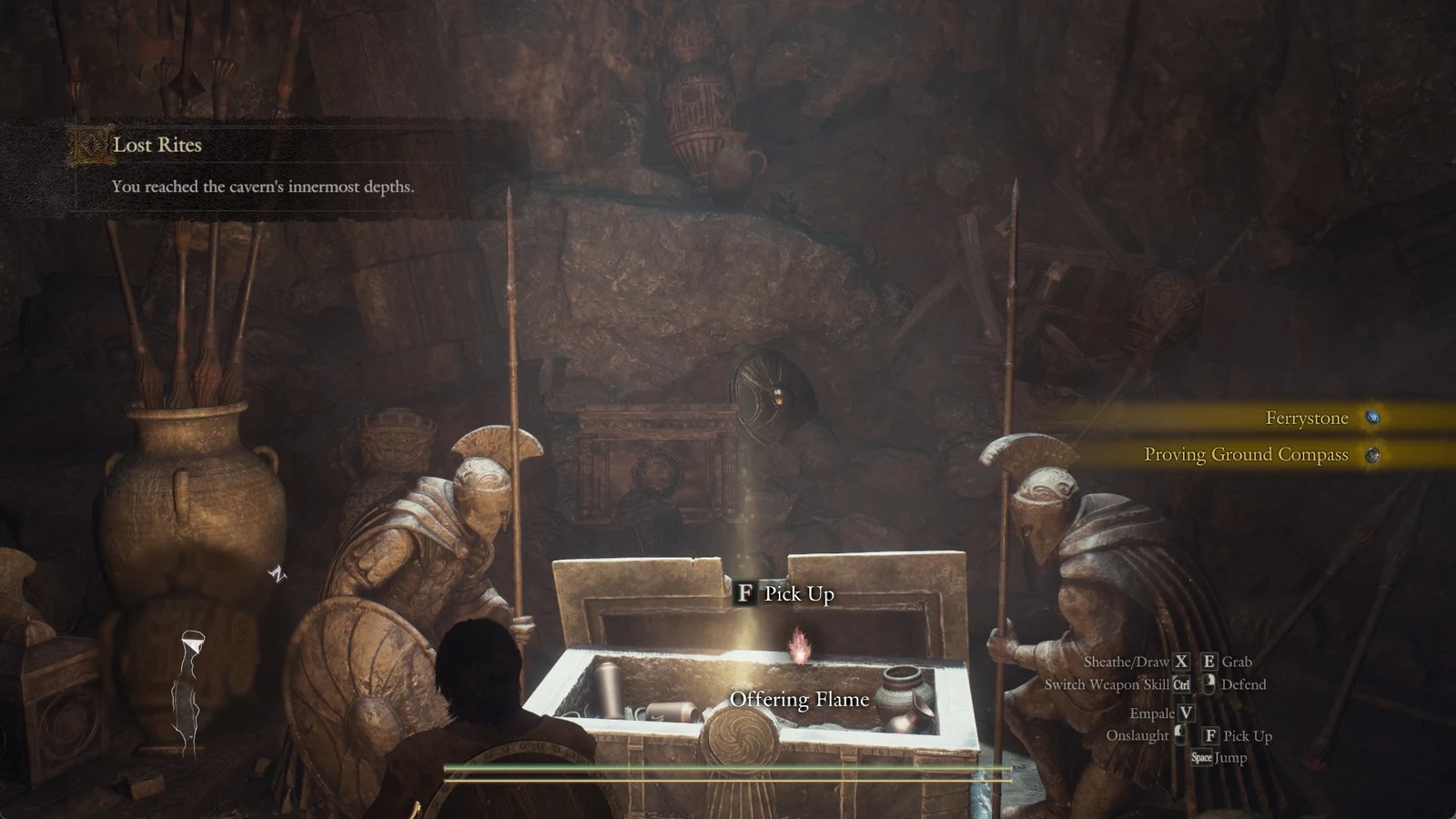 Open stone chest between two statues in a dim cave with a glowing pink flame above it and a pick-up prompt.