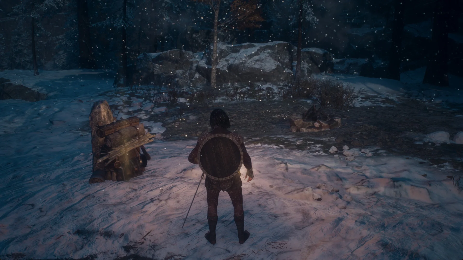 The Arisen with a lit lantern at night beside a ring of stones in the snow and a bundled supply pack by a stump