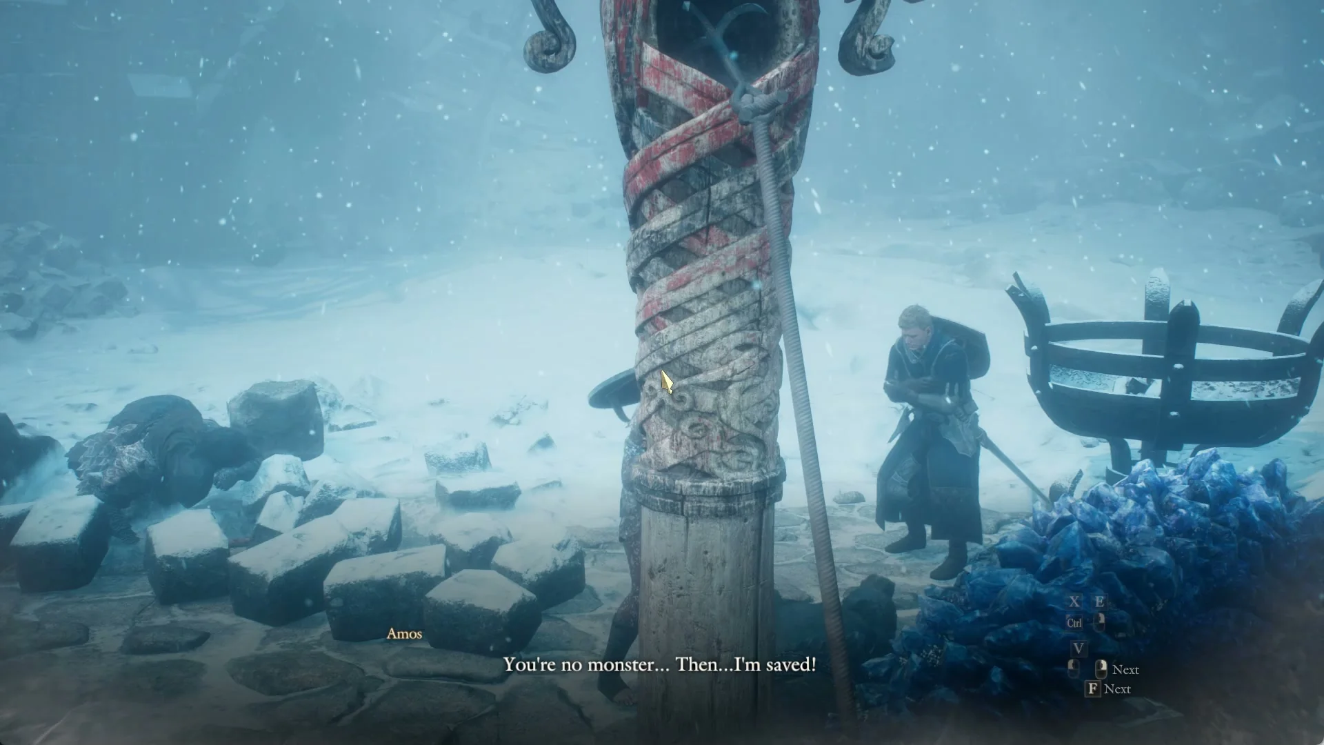 Amos stands beside a round iron brazier and a carved post wound with red and white bands with a rope tied to it