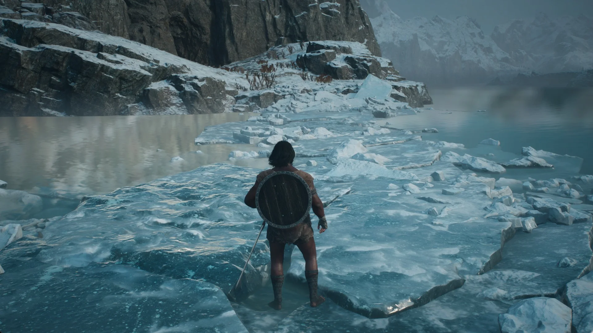 A narrow strip of ice slabs and floes leading toward the rocky southern shore with open water on both sides