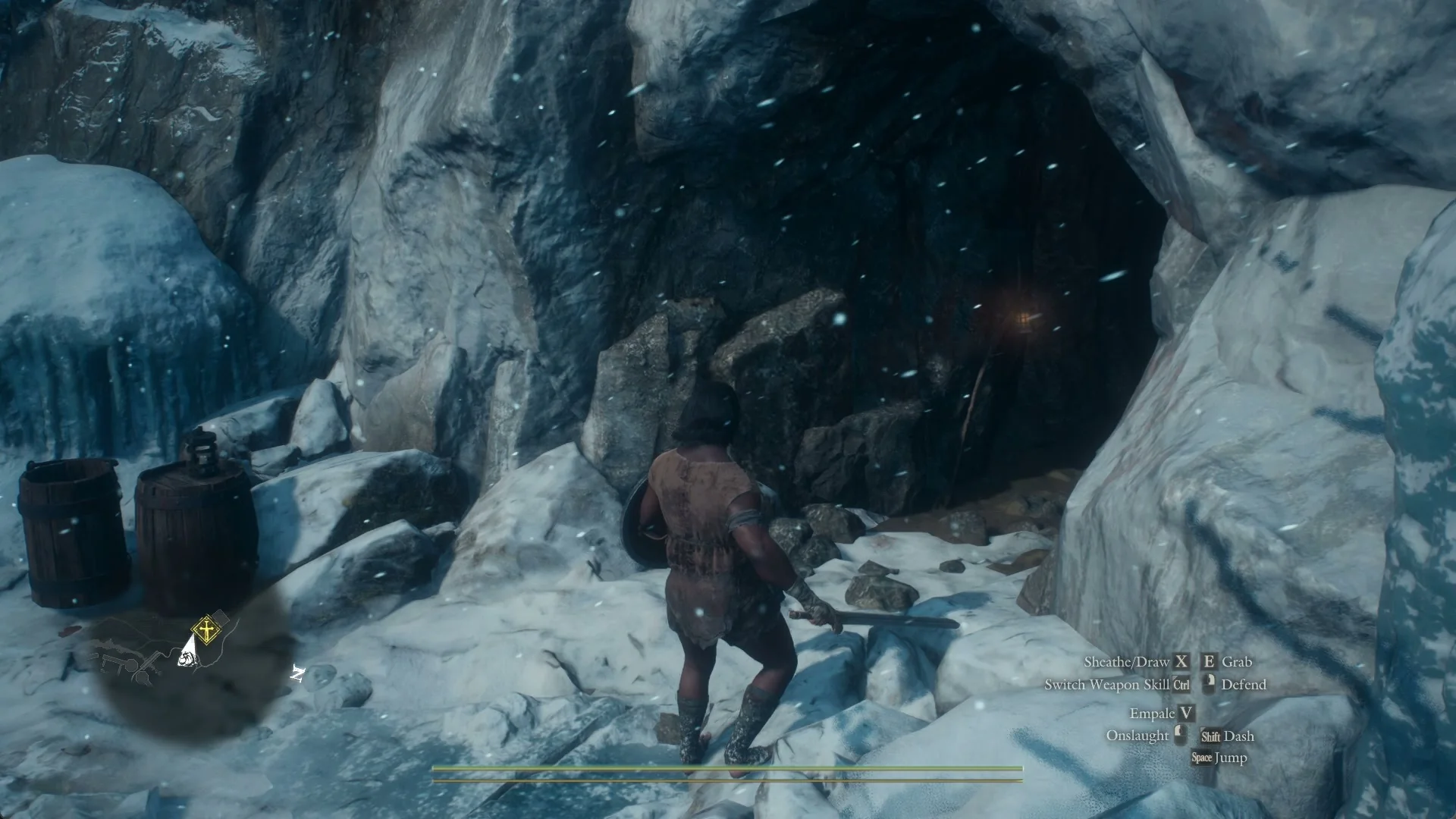 The cave mouth of Northwall Campground in falling snow, with two barrels at its left side