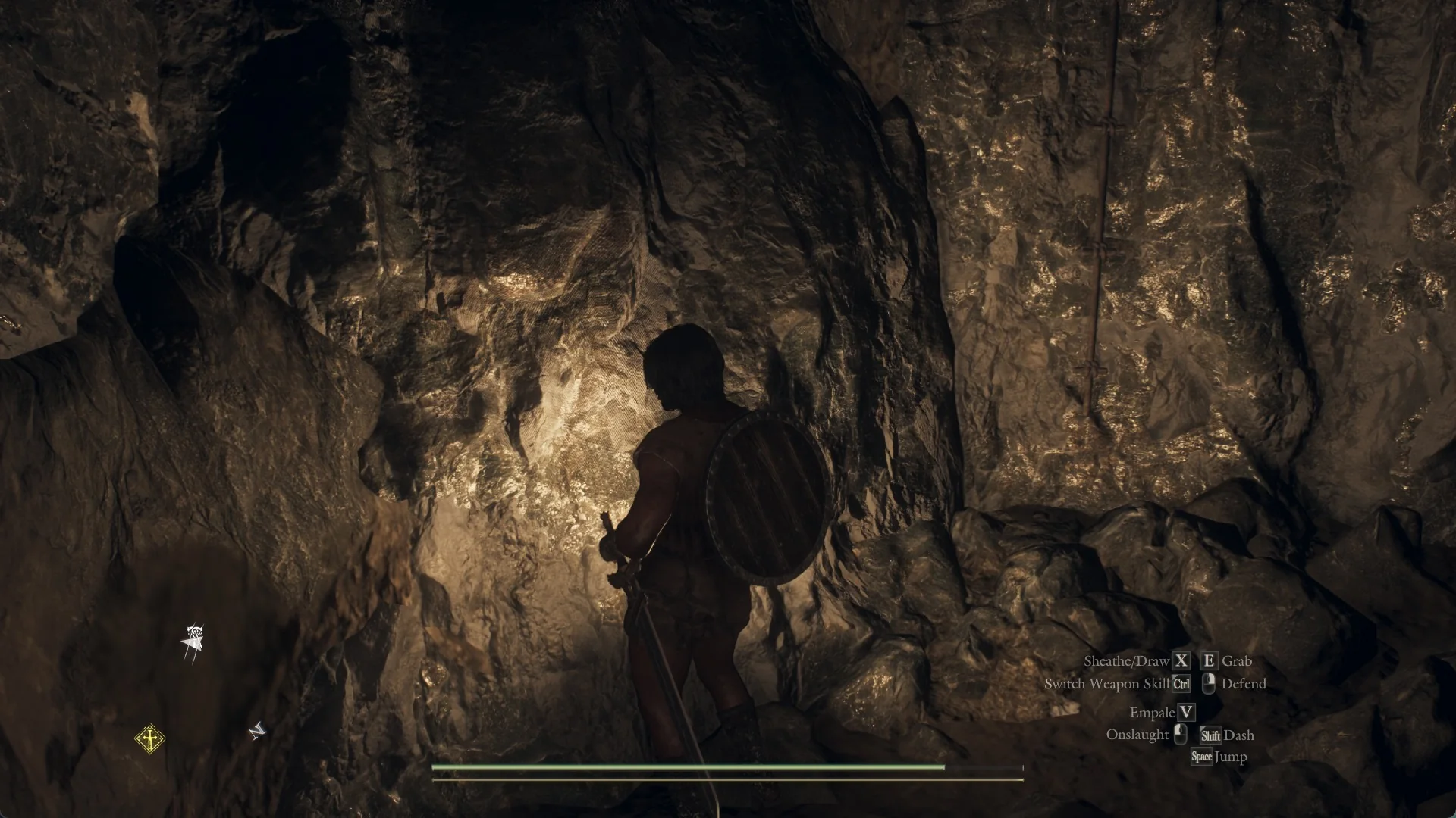 The Arisen on the rocky floor of the pit below the tether post, lantern lighting the cave wall