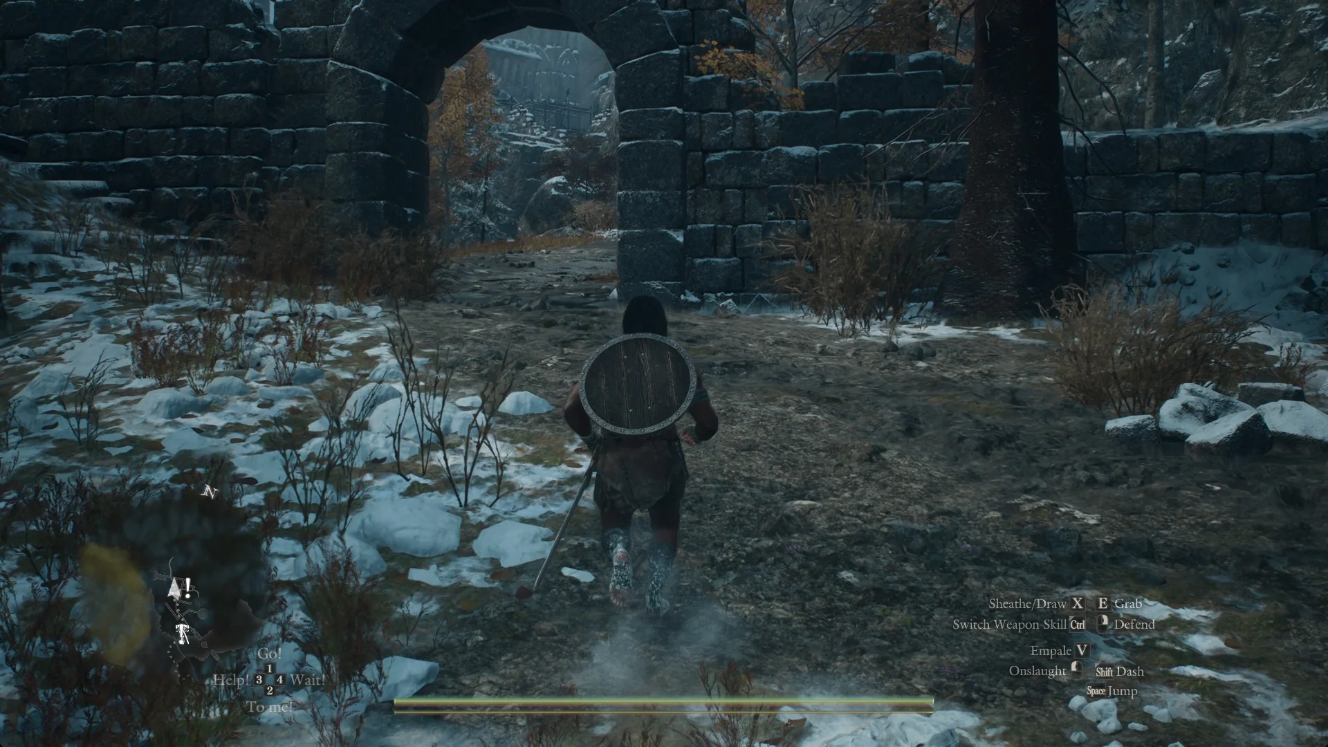 The Arisen walking toward a ruined stone arch in a broken wall on a snowy trail