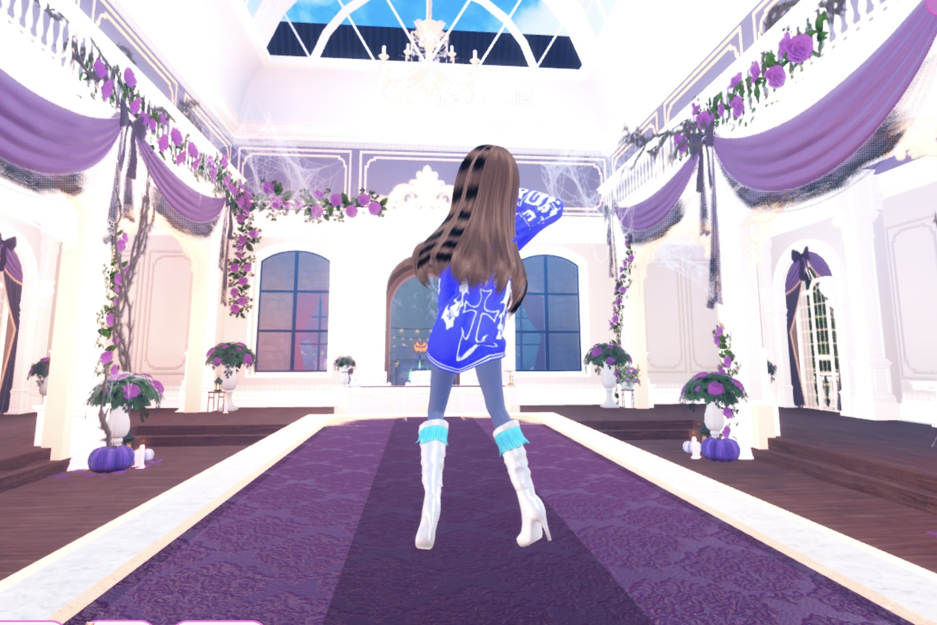 Back view of the streetwear cover look on the Freeplay Runway: blue hoodie with white print, silver knee boots with cyan fringe