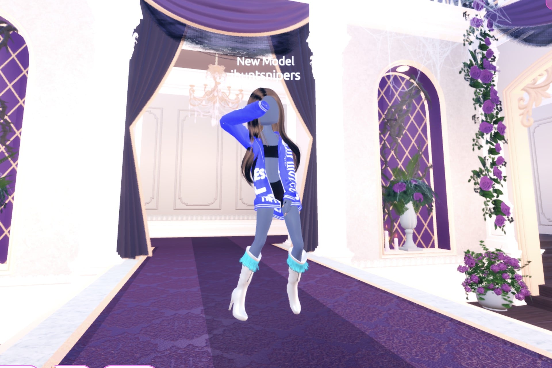 Front view of the streetwear cover look on the Freeplay Runway: royal-blue hoodie with white skull print and lettering, silver boots with cyan fringe, one arm raised across the face
