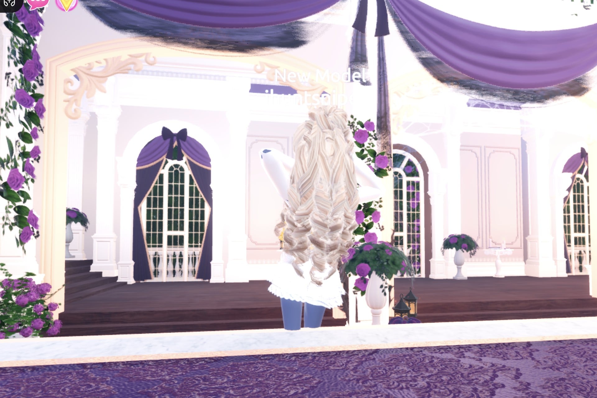 Goddess look from the back: long pale blonde curls over the white dress