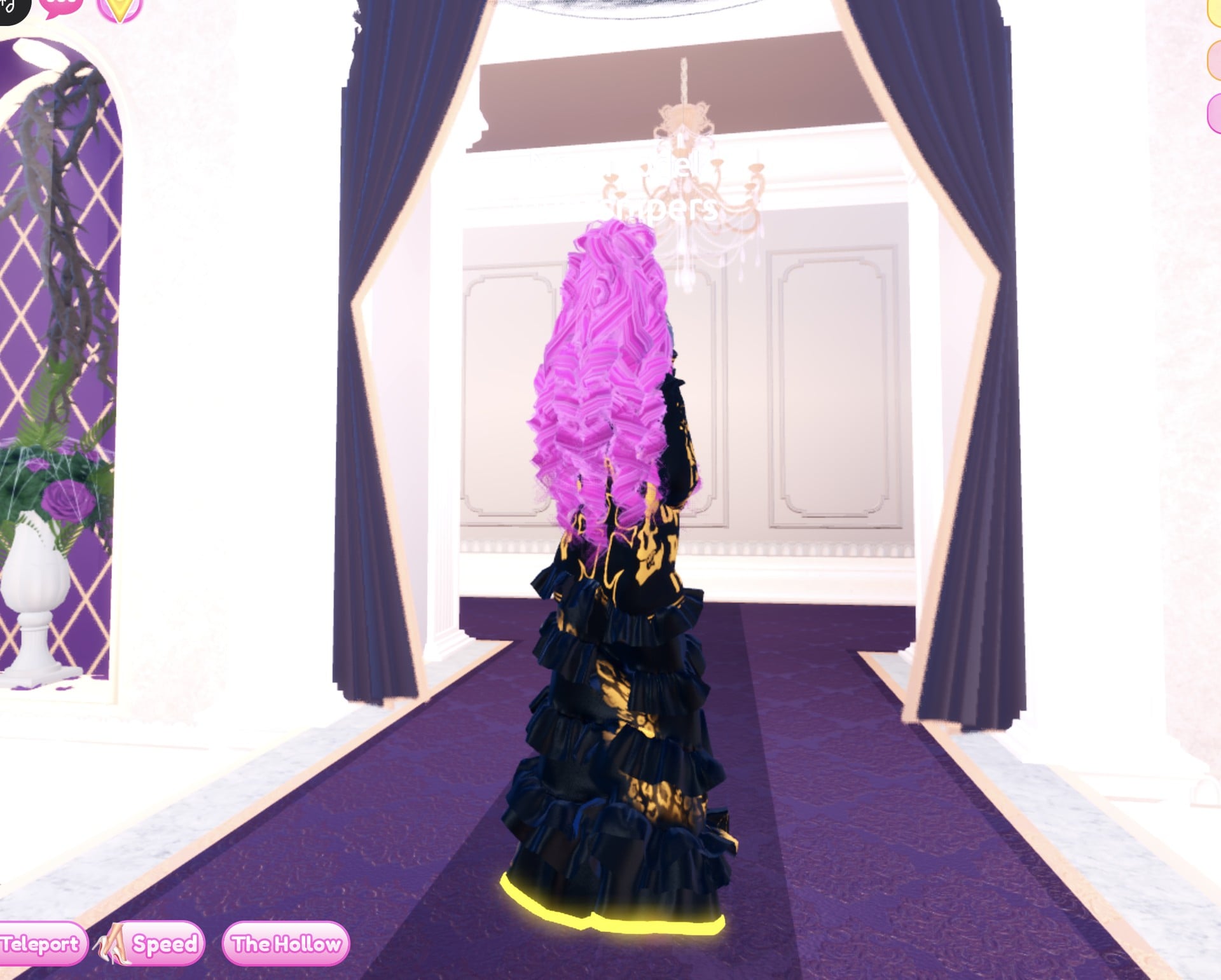 Black and gold look from the back: long pink curls, black jacket and the black gown with gold print and a glowing hem