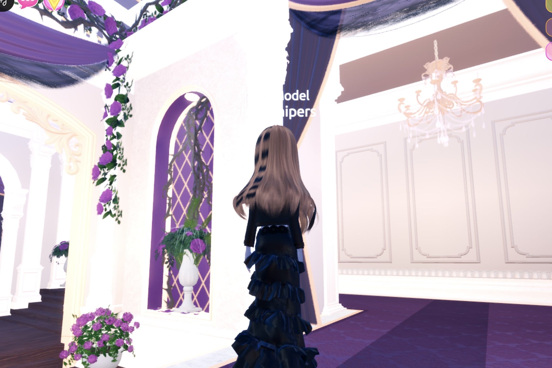 All-black look from the back: long brown hair over the black jacket and the tiered black gown