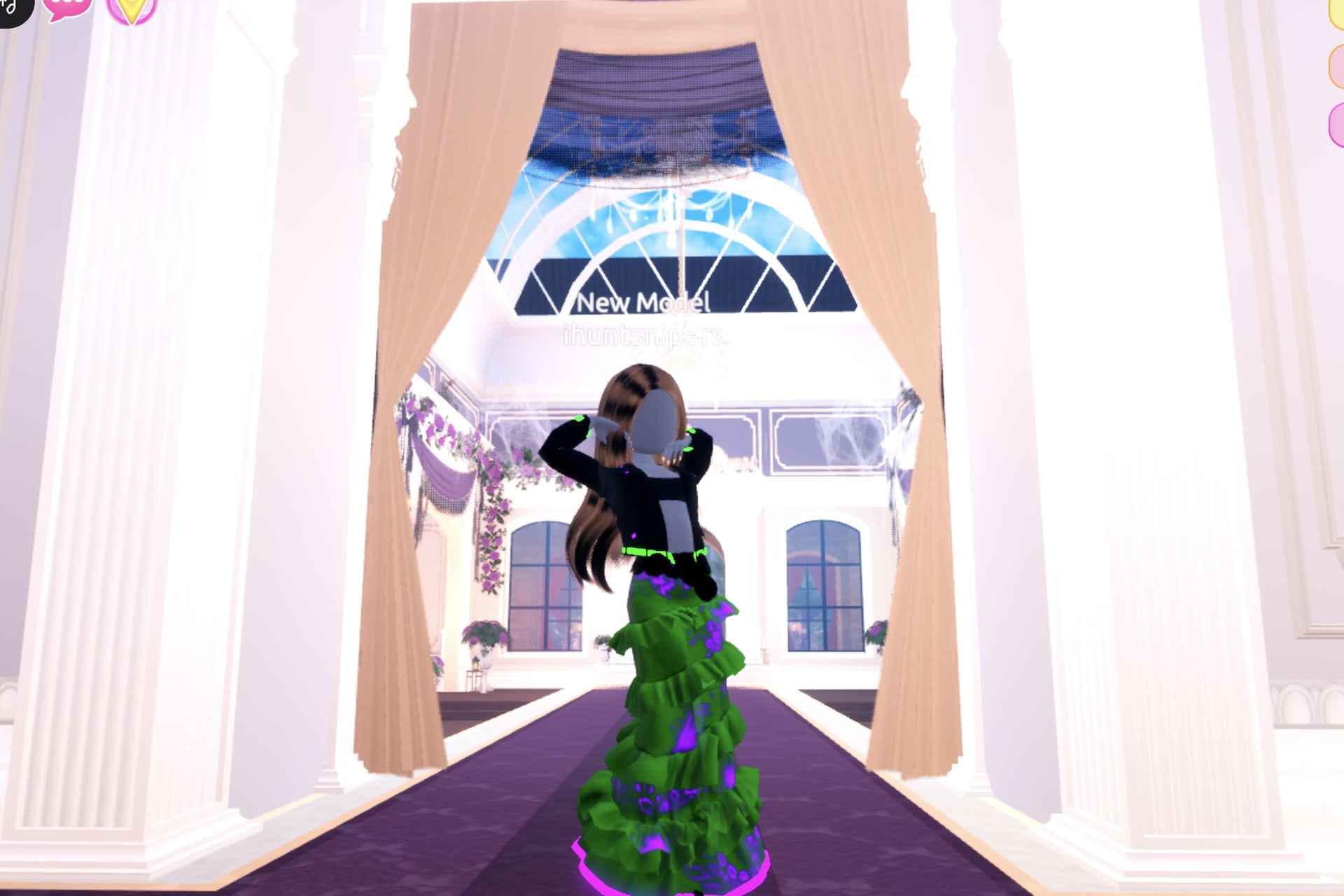 Alchemist look on the Freeplay Runway: cropped black jacket with a glowing green band over a green ruffled gown with a glowing purple hem