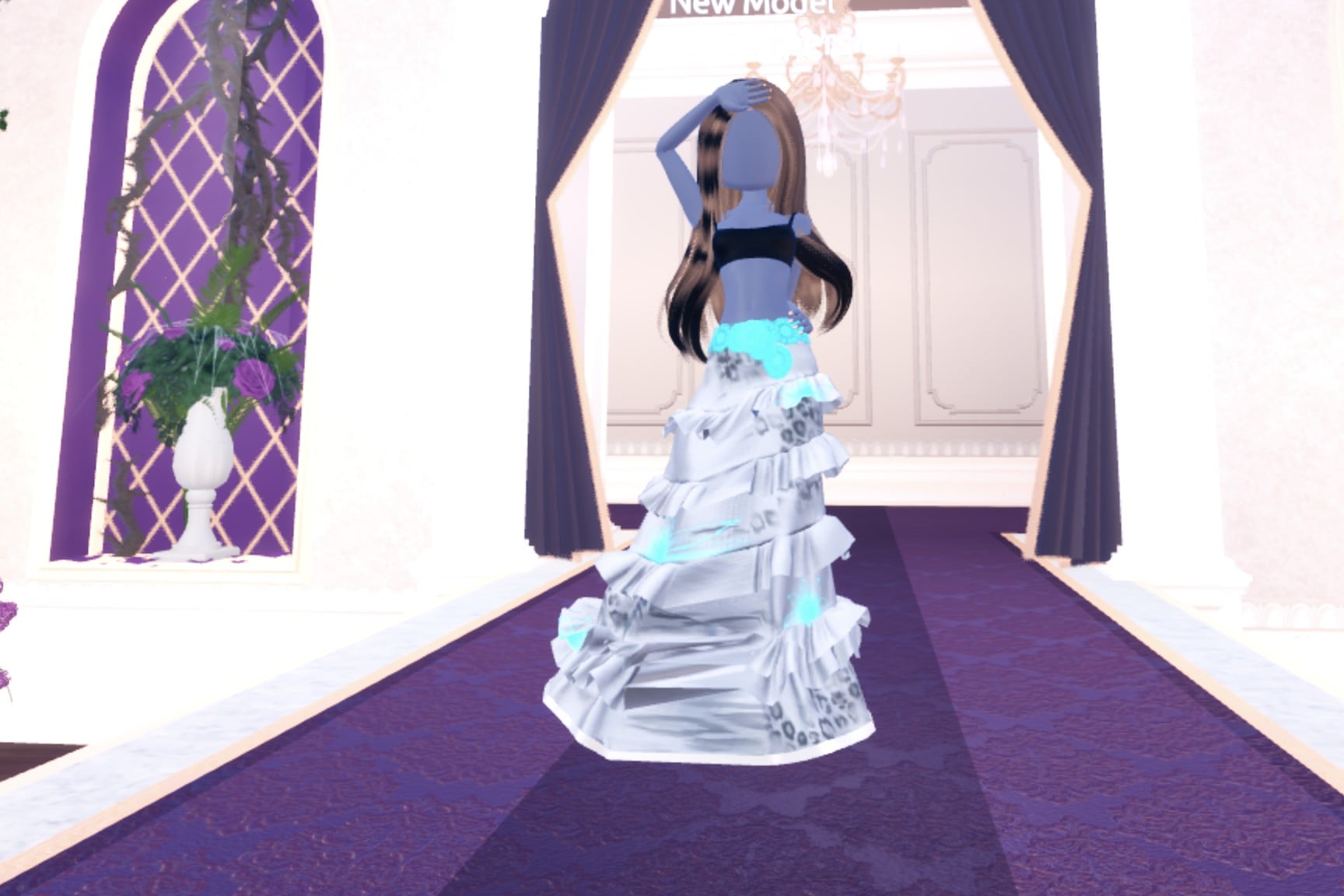 Front view of the metallic silver gown look on the Freeplay Runway, with cyan flower details at the waist