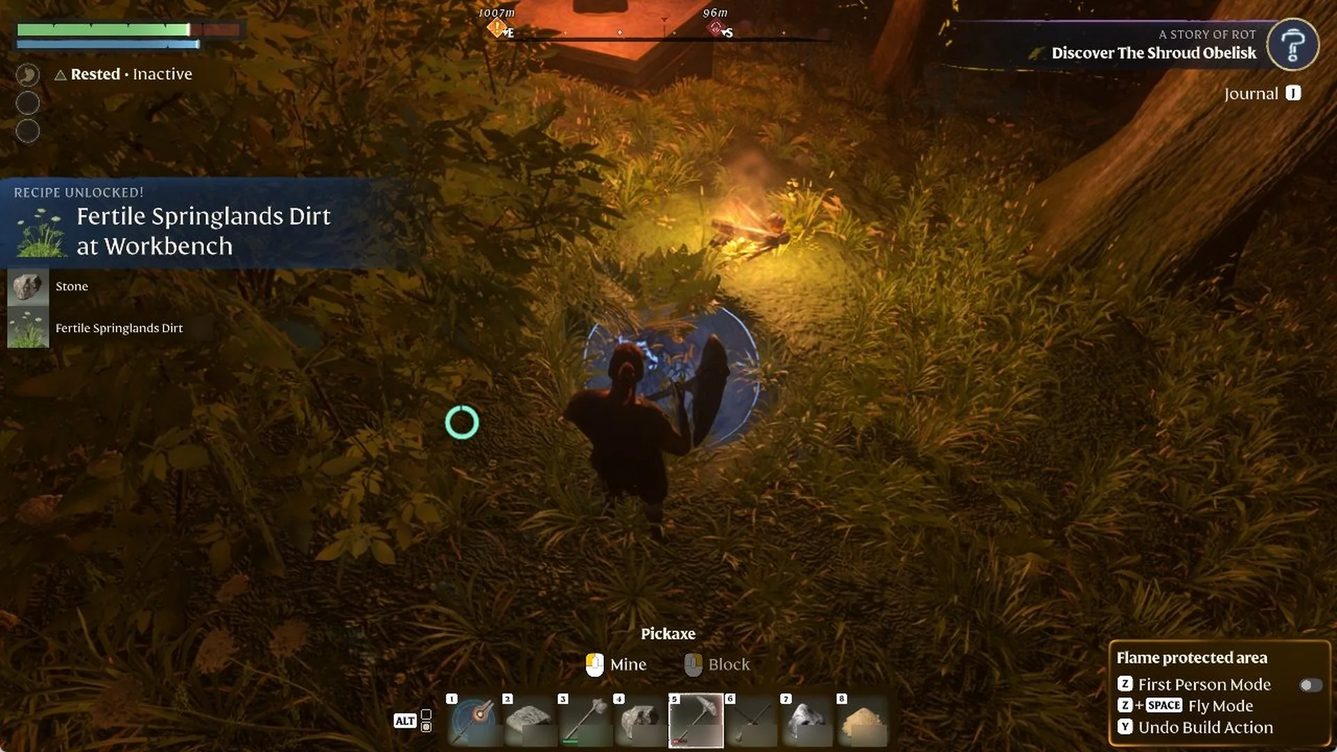 Enshrouded character holding a Pickaxe in grass beside a campfire at night, with a 'RECIPE UNLOCKED! Fertile Springlands Dirt at Workbench' banner