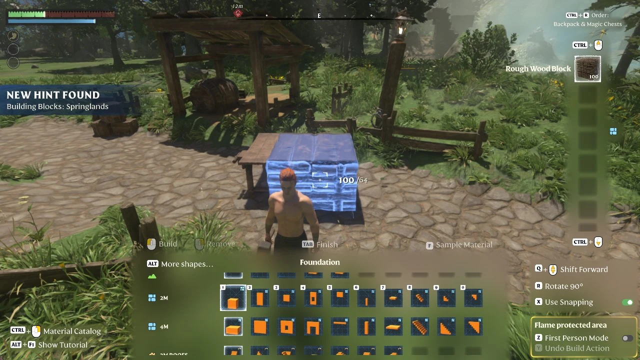 Player in build mode placing a blue ghost wooden block near a cobbled path, with the Foundation shape panel at the bottom.