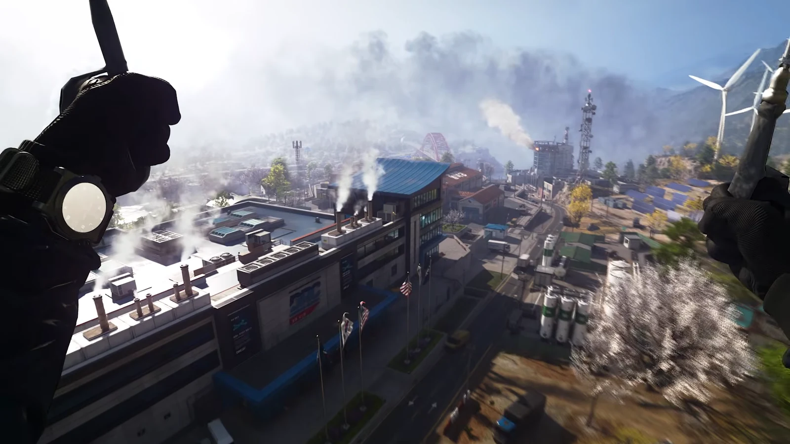 First-person parachute descent over an industrial city, gloved hands holding the straps