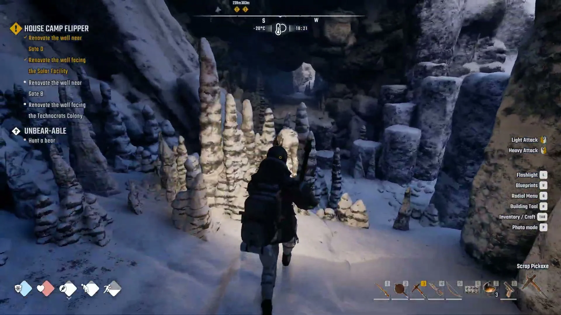 Broad cave chamber with a snow floor and rows of tall stalagmites, the character walking in with a pickaxe