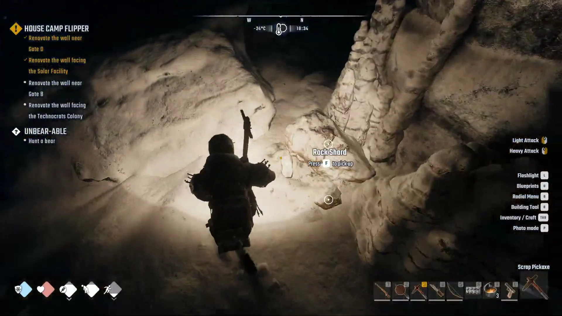 Narrow rock tunnel lit by a flashlight with the prompt Rock Shard, Press F to pick up