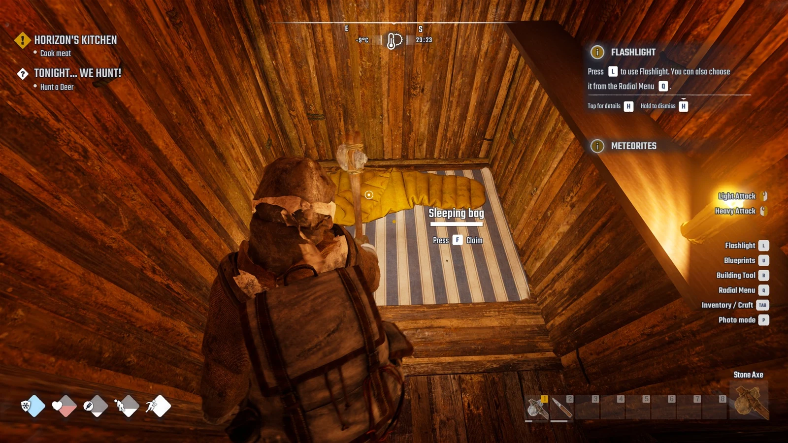 Player in a log shelter looks down at a yellow sleeping bag on a striped mattress, with quest tracker and control hints on screen.