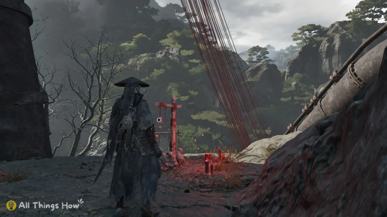 Soul in a wide straw hat seen from behind, facing a red cross shrine with candles beside red threads and misty cliffs.