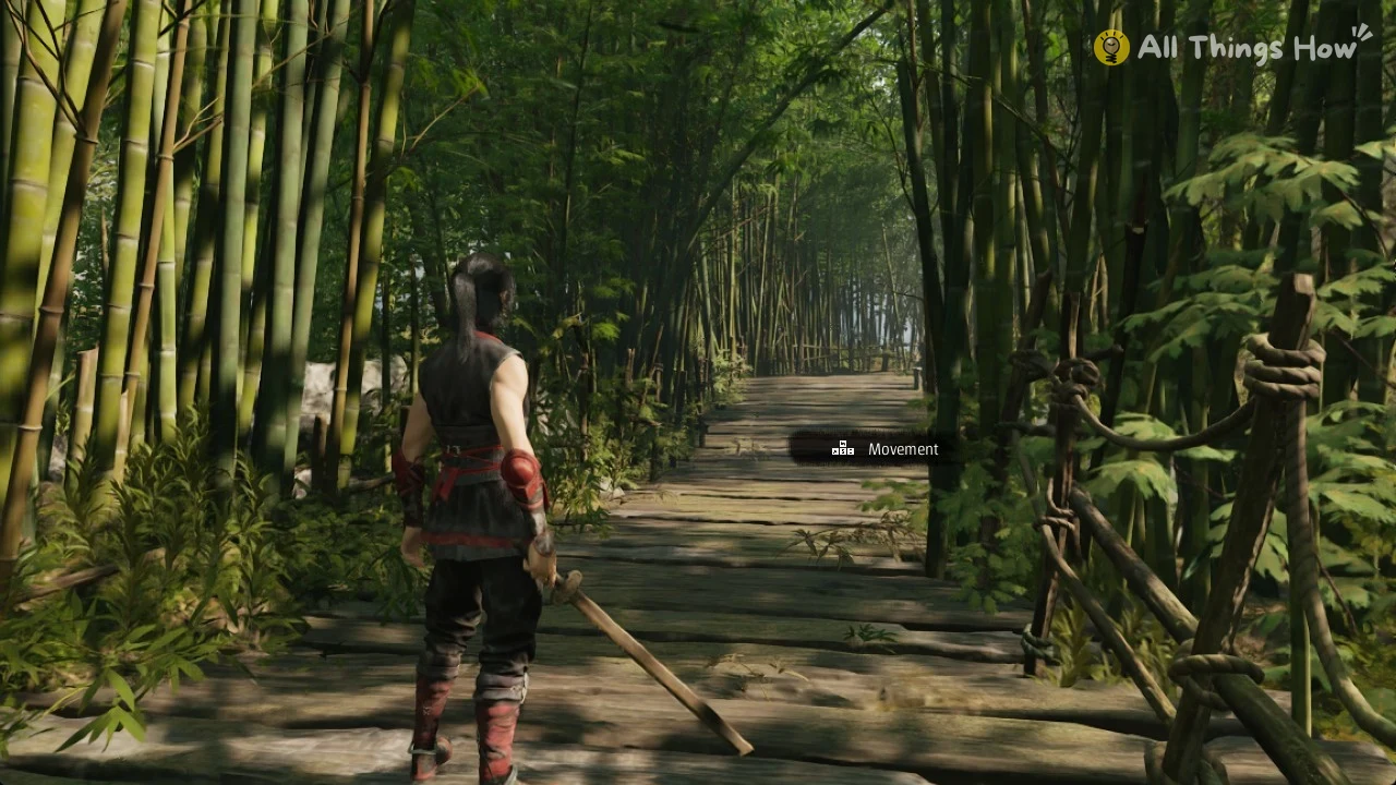 Dark-haired warrior in black and red holding a wooden sword stands on a plank path through a bamboo forest.