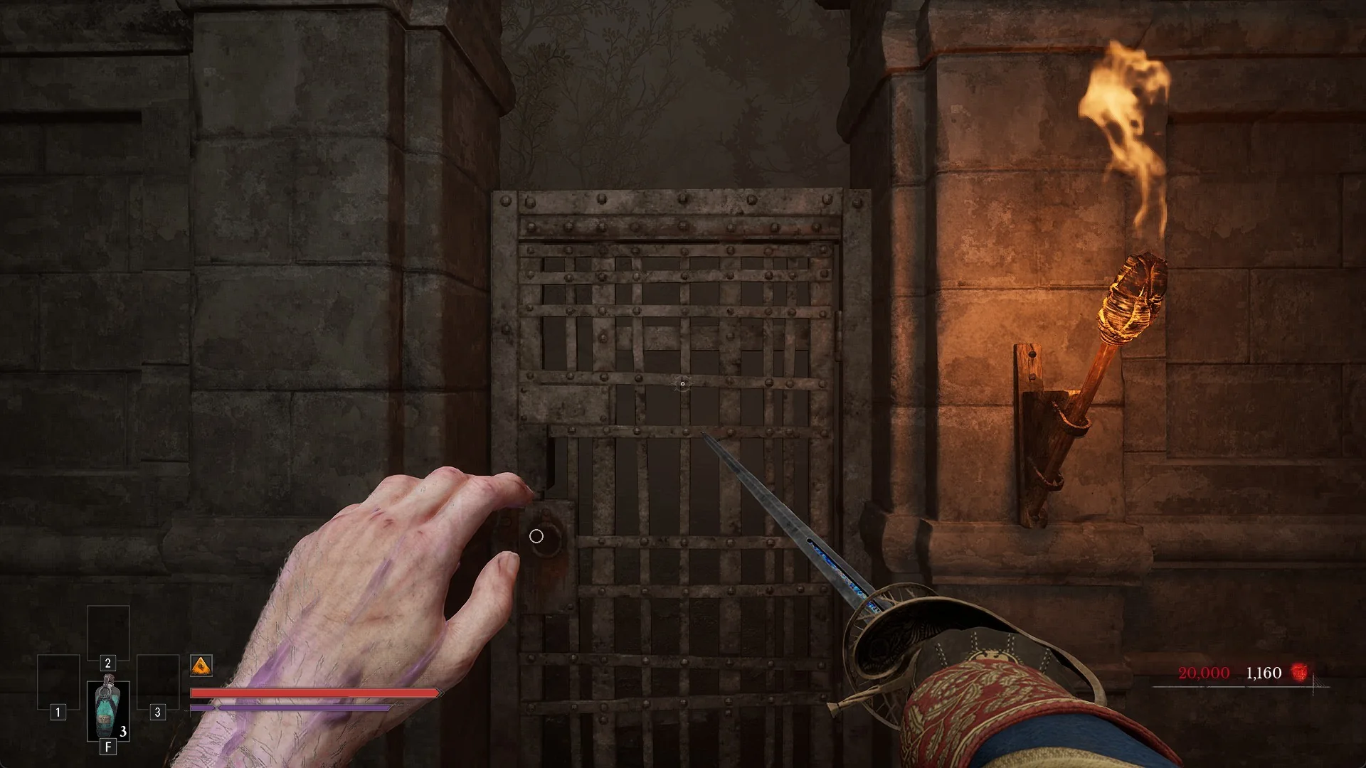 The Outward Pass Gate up close, an iron grille beside a lit torch