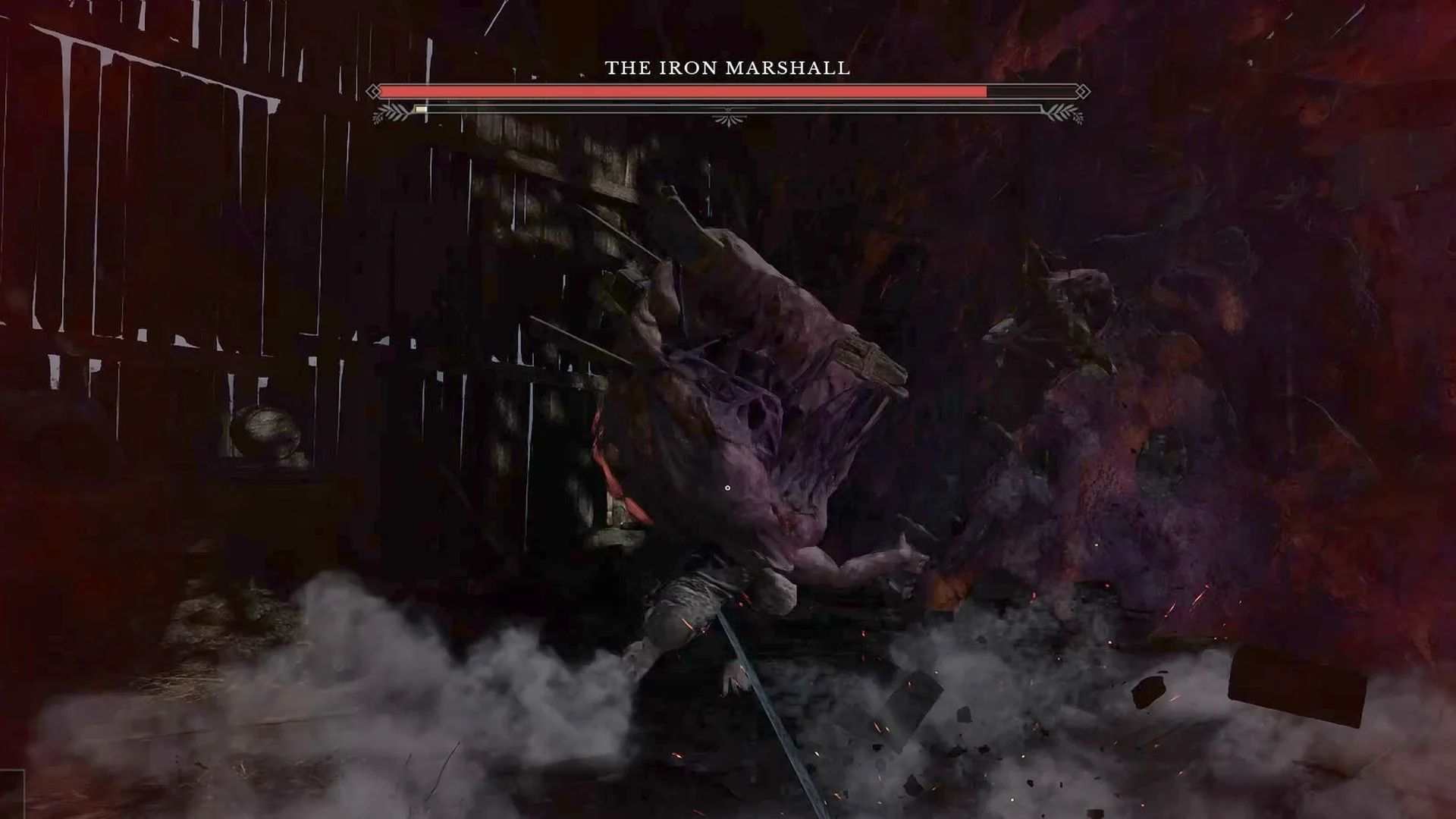 Grey smoke and debris bursting from the barn floor at the Iron Marshall's feet