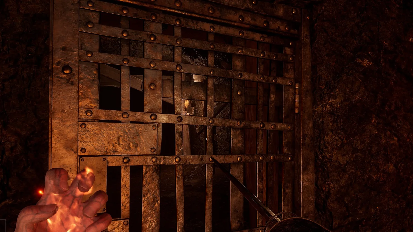 A riveted iron grille door in a timber frame at the mouth of a dark tunnel